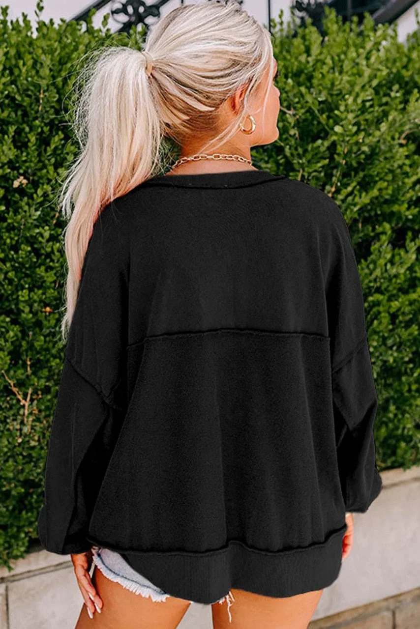 Zwarte Henley sweater met lage schouders en knopen, casual en stijlvol